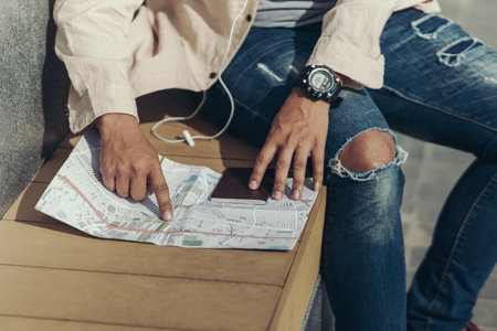 Tourists point their fingers at the map to find attractions, restaurants or hotels.backpacker and...