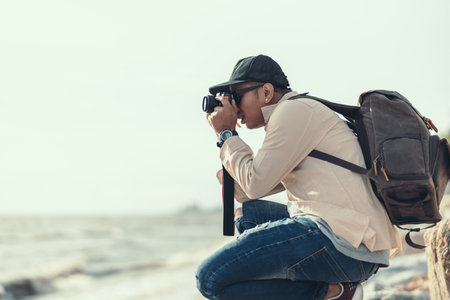 Tourists use camera to shoot sunset on the beach. backpacker and travel concept.の写真素材