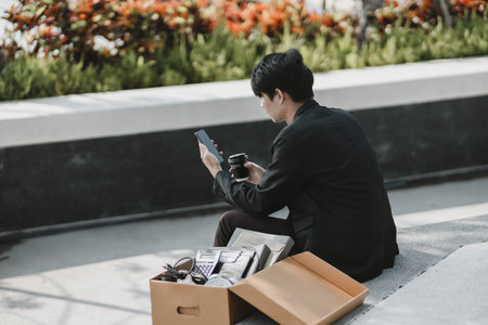 Employees fired or resigned from the company are using their mobile phones to search for jobs.
Unemployed, hiring job, quitting job concept.の写真素材