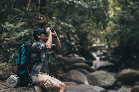 Hikers use binocular to see animals and view landscape  with backpacks in the forest. hiking and adventure concept.の写真素材