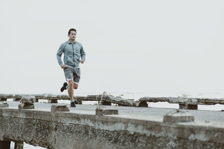 healthy lifestyle young fitness man running at seaside old bridge. Outdoor workout,  Healthy...