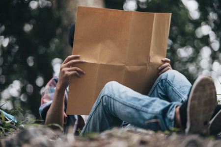 Lost hiker with backpack checks map to find directions near the river in the forest. hiking and...