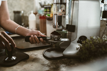 barista use bottomless filter with grinder machine at coffee shop. coffee maker concept.の写真素材
