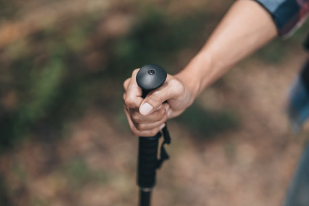 Hikers use trekking pole with backpacks and hold tent bag walking through the forest. hiking and adventure concept.の写真素材