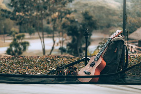 Camping equipment, bags, shoes, ukulele, tripod beside the tent in the morning. Object camp, Travel and vocation concept.の写真素材