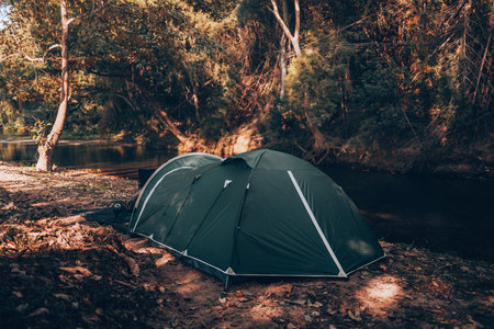 Green tent on the grass in the forest The view behind is the mountain in the morning. Camping, Travel and holiday concept.の写真素材