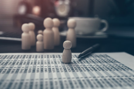 The wooden doll represents the employee of the company in workplace and document budget, calculator and coffee cup on the table.  Corporation, Enterprise concept.の写真素材