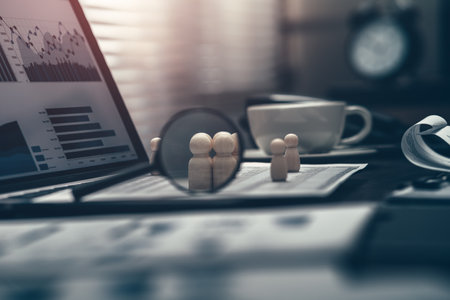The wooden doll represents the employee of the company and magnifying glass view them on laptop in workplace.  Search or find new job and Corporation, Enterprise concept.の写真素材