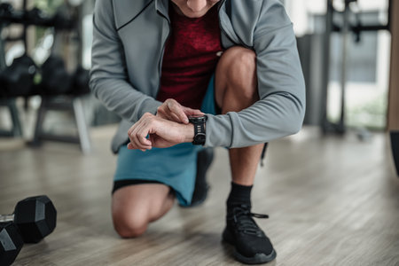 A man checking at smartwatch during training  at gym. Fitness, workout and traning at concept.の写真素材