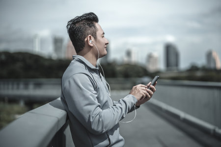sport man listen music earphone and  use smartphone Fitness application, social media, listening to...