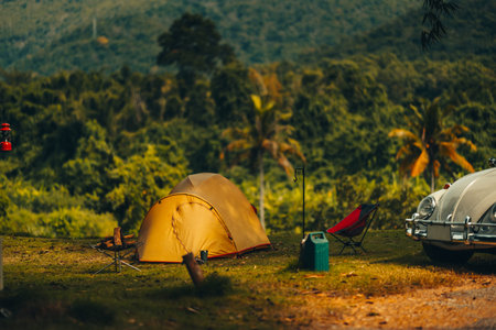 A tent on the grass with a view of the mountains in the background and sunlight. Holiday, Travel,...