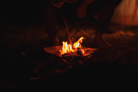 Hikers make a bonfire in front of tent. Campfire, camping concept.の写真素材