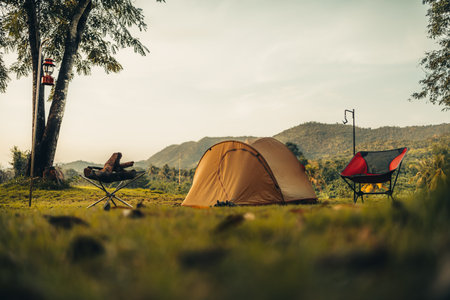 A tent on the grass with a view of the mountains in the background and sunlight. Holiday, Travel, Long weekend, Vacation and camp concept.の写真素材