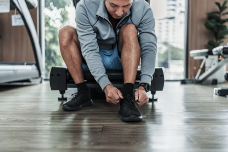 man's hands tying shoe laces in the gym.  Fitness, workout and traning at concept.の写真素材