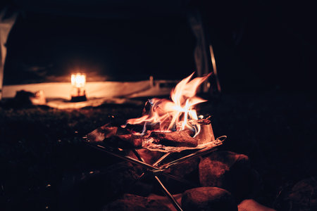 Campfire in front of tent at night. Camping concept.の写真素材
