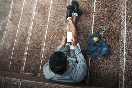 A man use smartphone Fitness application, social media, listening to music.  Health and Lifestyle in big city life concept.の写真素材