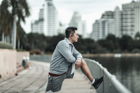 A man stretching his muscle  in the city center park before  cardio workout, running.  Health and...