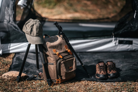 tents pitched on hillsides beside streams of water from waterfalls. hiking bag, hiking shoes on the...