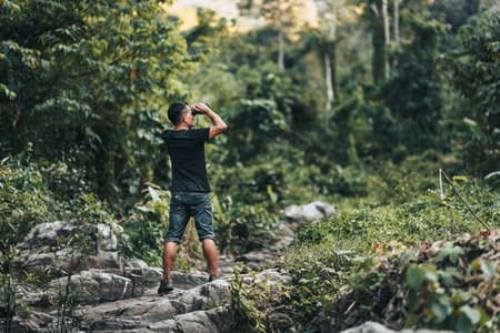 Hikers use binocular to see animals and view landscape with backpacks in the forest. hiking and adventure concept.の写真素材