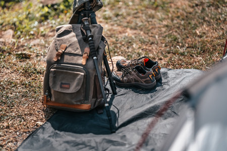 tents pitched on hillsides beside streams of water from waterfalls. hiking bag, hiking shoes on the ground.の写真素材