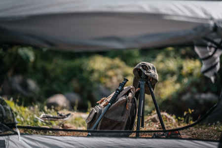 tents pitched on hillsides beside streams of water from waterfalls. hiking bag, hiking shoes on the ground.の写真素材