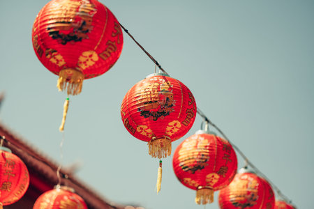 Red Chinese lantern(Translation Hieroglyph text Happy New Year) hanging in a row during day time for Chinese new year celebration.の写真素材