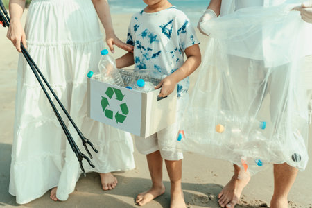 An Asian family is carrying boxes and garbage bags that collect plastic bottles from the beach to...