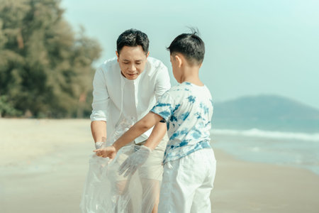 On the beach, a father and son carry bags to collect trash. Clean up the dirty sea or ocean and...