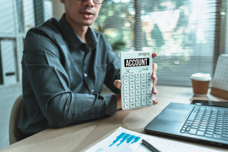 An accountant holds a calculator and it has the text "ACCOUNT" on the screen. Account, Finance, budget income and investment concept.の写真素材