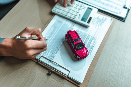 A car on reservation from and salesman hands write. Image represents the concept Insurance, protection, loan and guarantee.の写真素材