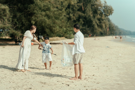 Family carry a bag to collect trash on the beach and clean up the dirty sea while collecting reusable plastic bottles.の写真素材