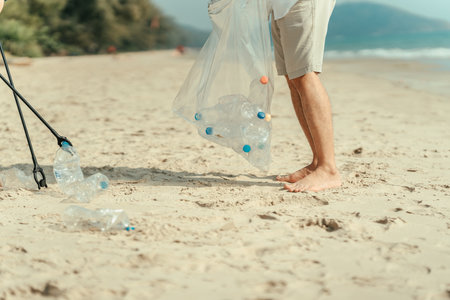 Family carry a bag to collect trash on the beach and clean up the dirty sea while collecting reusable plastic bottles.の写真素材