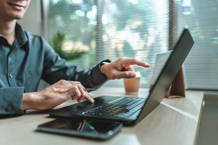 Businessman is hand working and typing on laptop and finger point to laptop screen. Business, corporate and finance concept.の写真素材