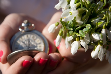 Snowdrops and old watch in the women hands の写真素材