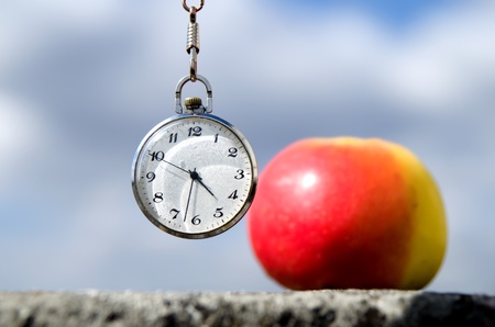 Old watch with apple, sky background の写真素材