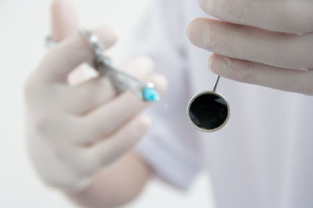 Dentist holding a syringe and mirror.の写真素材