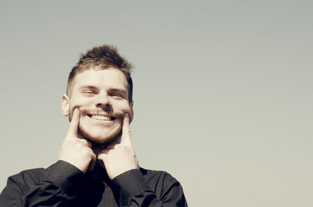 Man with a strained smile.