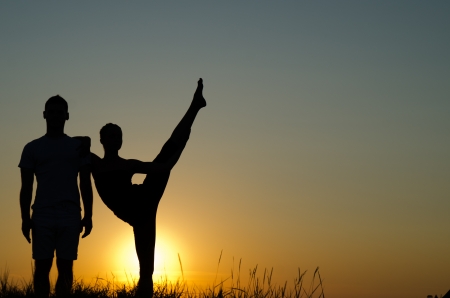 Acrobatic couple. Silhouette, sunset.の写真素材