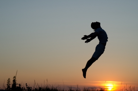 Guy jumping over sunset.の写真素材