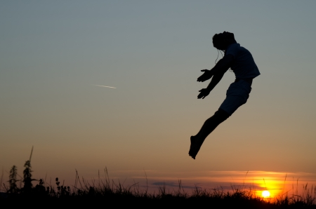 Guy jumping over sunset.の写真素材