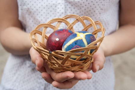 Woman hand holding basket with Easter eggs.の写真素材