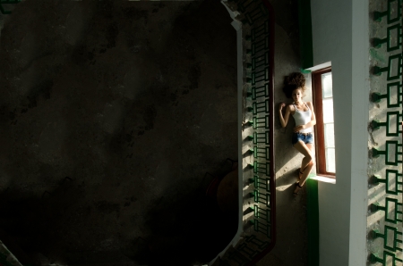 Young and pretty girl on a old fashion stairwell. Image has a lot of space to put any text.の写真素材