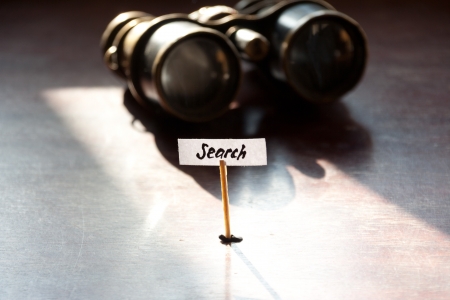 Search concept, old binoculars and an inscription searchの写真素材