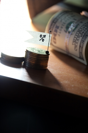 Percent growth concept. Sign, coins and roll of banknotes.の写真素材