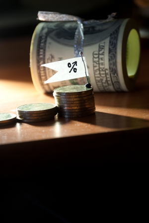 Percent growth concept. Sign, coins and roll of banknotes.の写真素材
