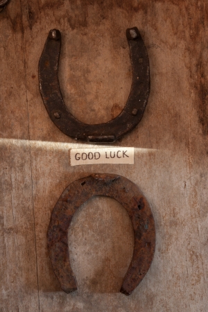 good luck inscription and  horseshoes over wooden backgroundの写真素材