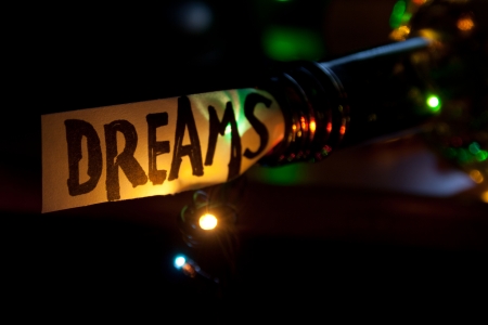 Dreams concept. The word dream, bottle and multicolored lightsの写真素材