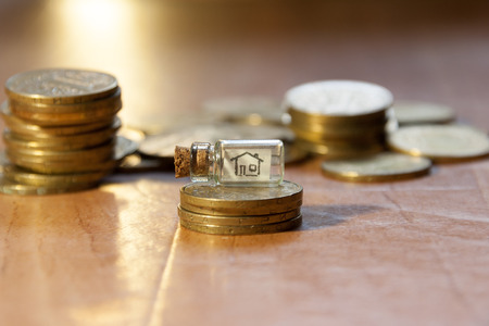 money for home concept, house drawing, glass jar and gold coinsの写真素材