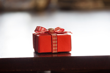 red gift box on a brown tableの写真素材