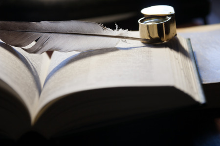 Close-up of open book, quill pen  and magnifying glassの写真素材